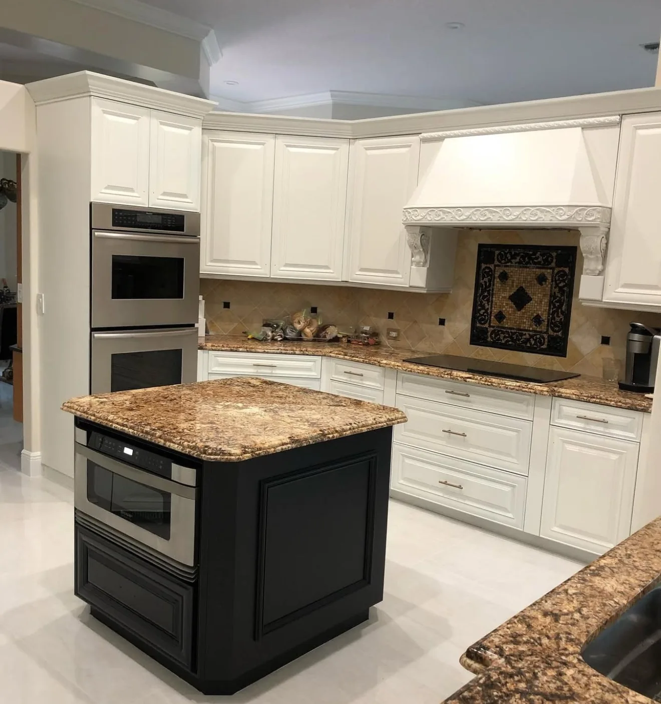Refinished white kitchen cabinets with a dark island in South Florida