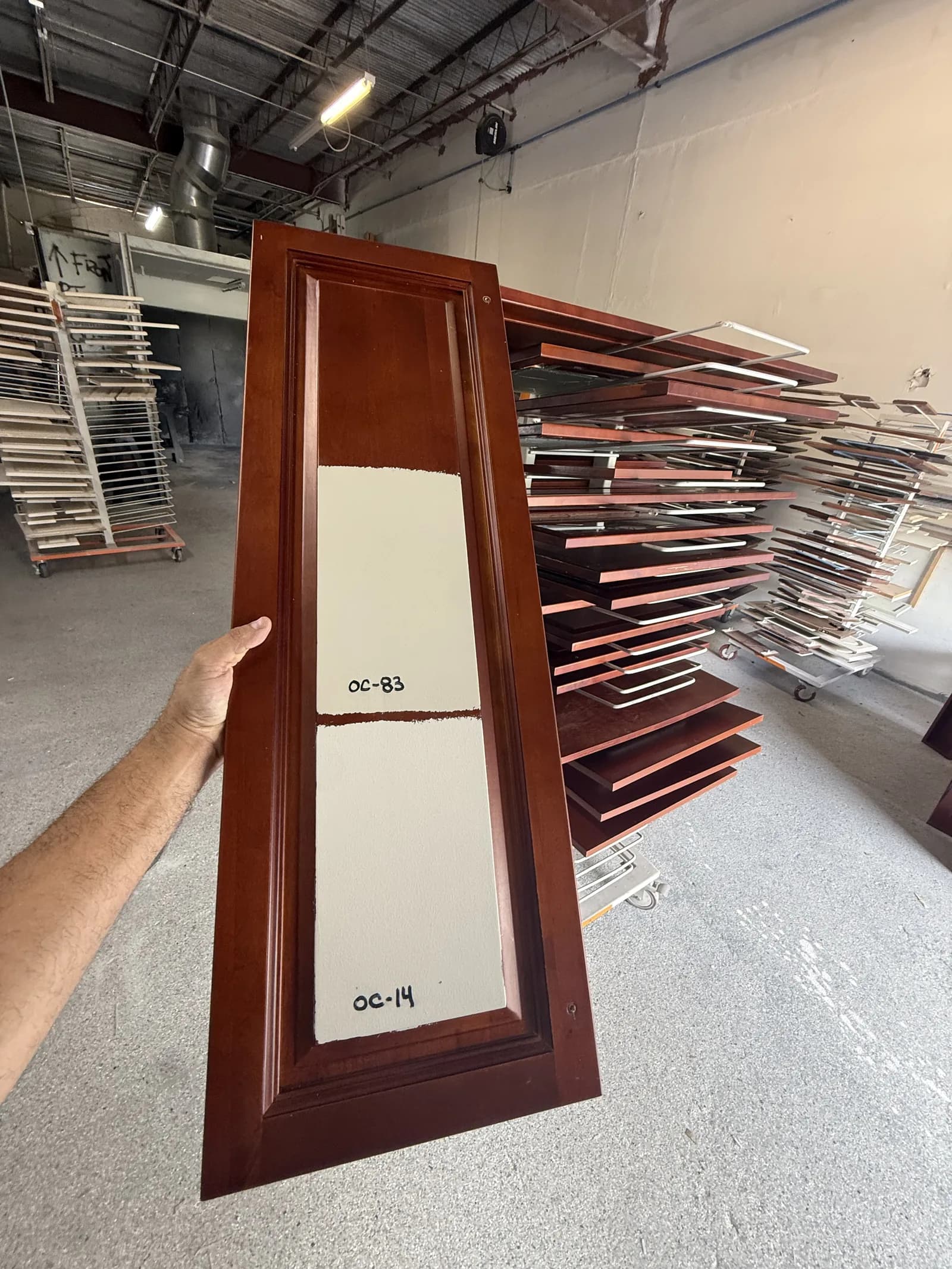 Cherry cabinet door half sprayed white on the shop rack